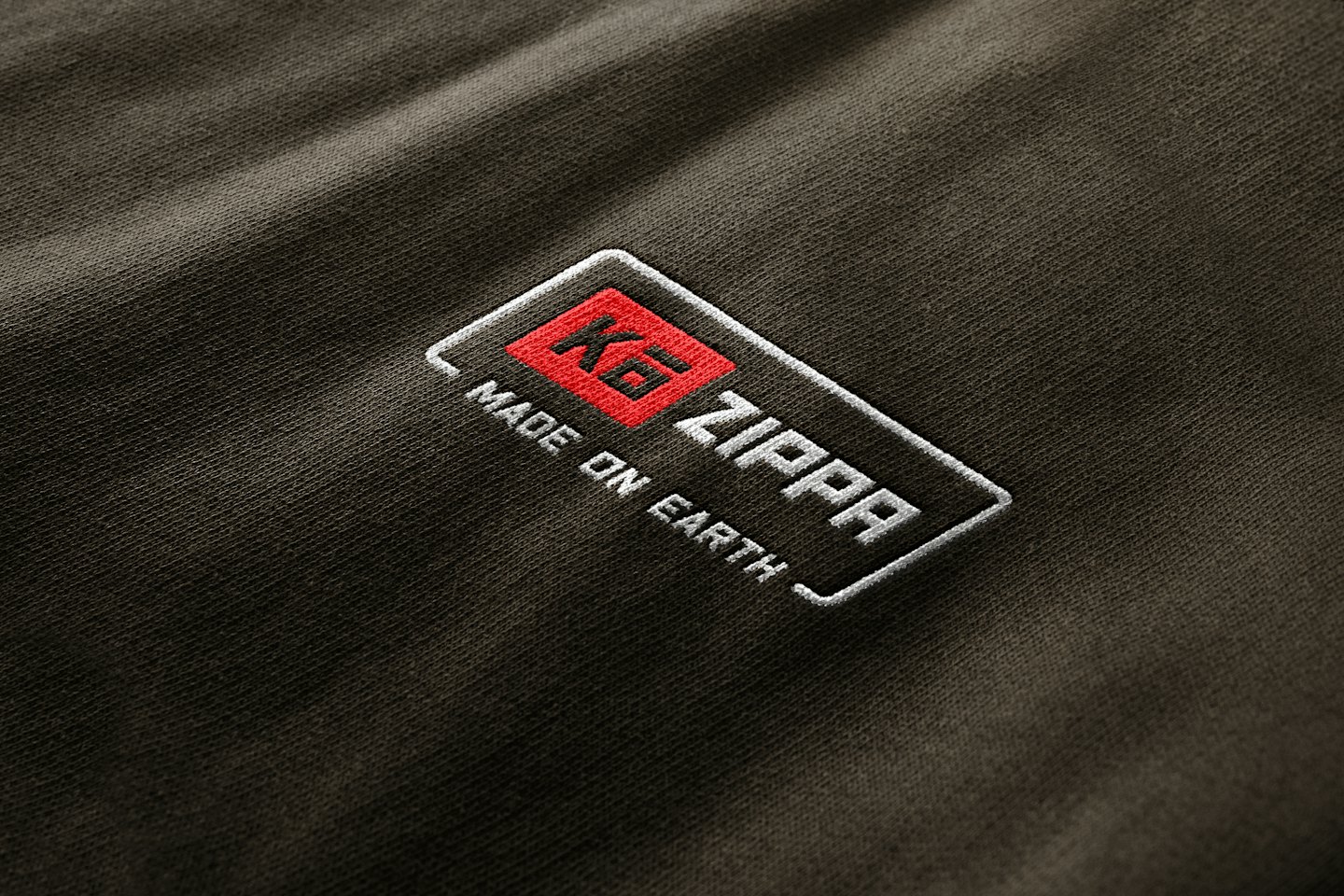 Embroidered Zippa logo and text stitched onto dark fabric.